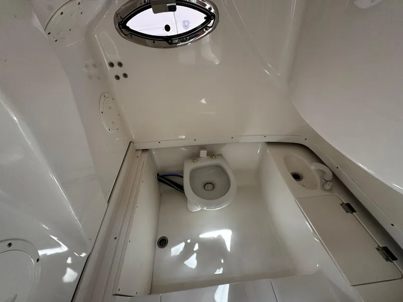 Slide: The Image of 2016 Robalo R260 Center Console boat interior with compact marine toilet. - 24