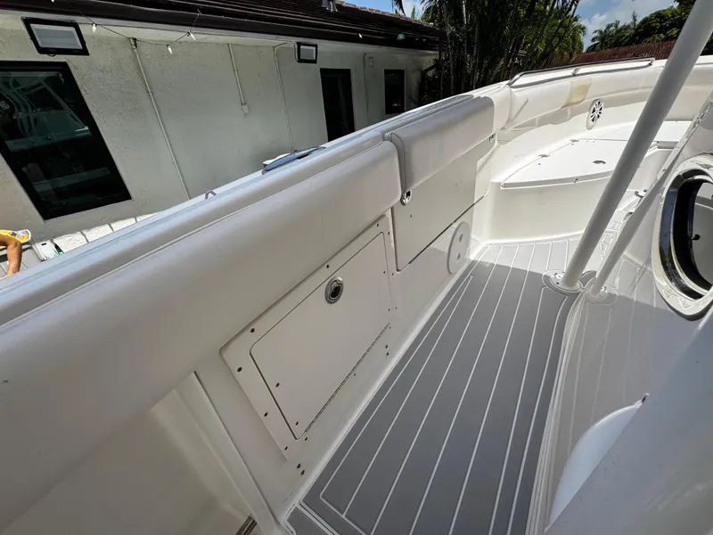 Slide: The Image of 2016 Robalo R260 Center Console boat interior with white seating and storage compartments. - 27