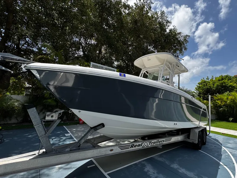 Slide: The Image of 2016 Robalo R260 Center Console boat on trailer, parked outdoors under a clear sky. - 3