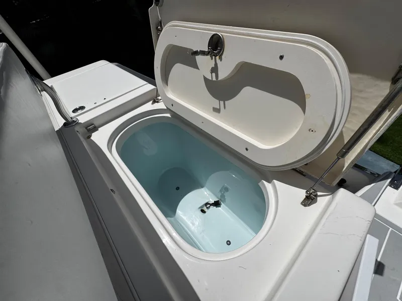 Slide: The Image of 2016 Robalo R260 Center Console livewell with open lid, showcasing interior design. - 40