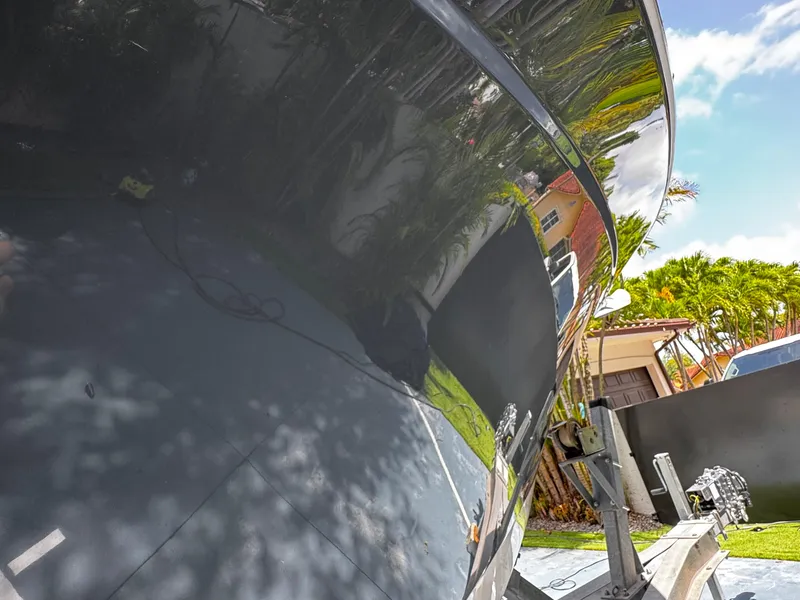 Slide: The Image of 2016 Robalo R260 Center Console boat reflecting surroundings, parked outdoors. - 6