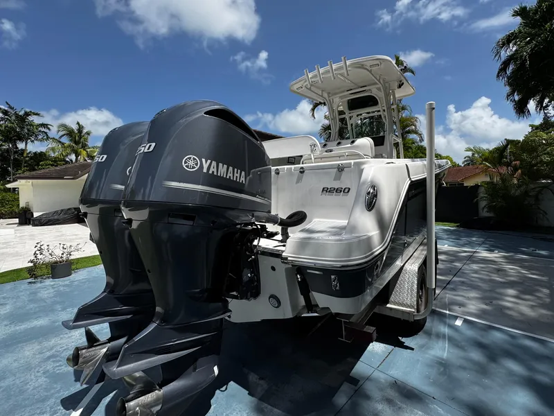 Slide: The Image of 2016 Robalo R260 Center Console boat with twin Yamaha engines, parked outdoors. - 8