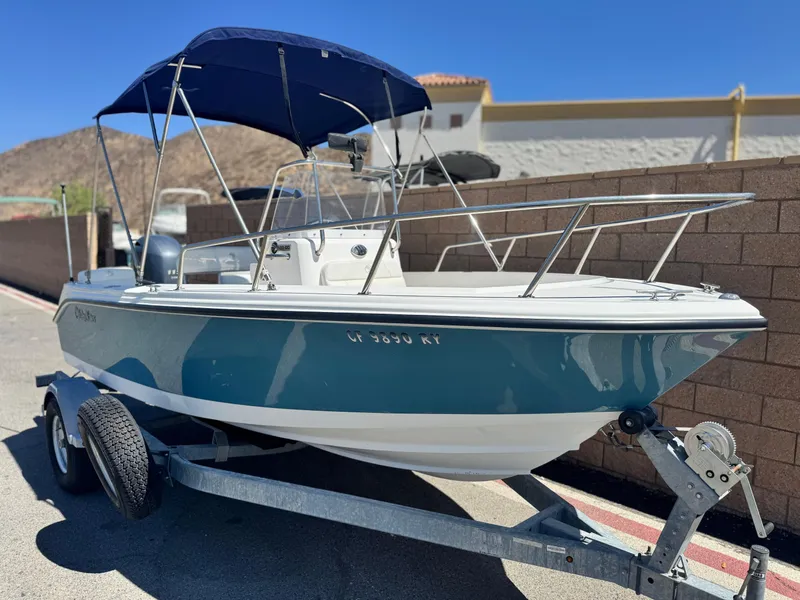 Slide: The Image of 2017 Edgewater 170CC boat on trailer with blue canopy, parked outdoors. - 1