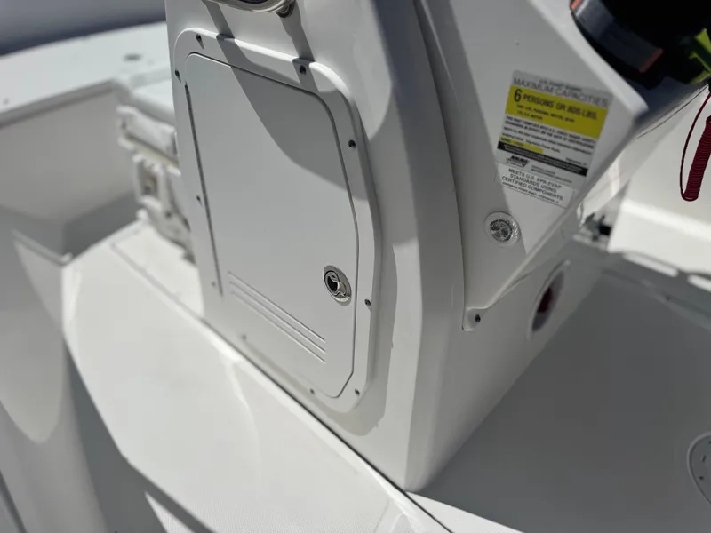 Slide: The Image of 2017 Edgewater 170CC boat console with storage compartment and safety label. - 26