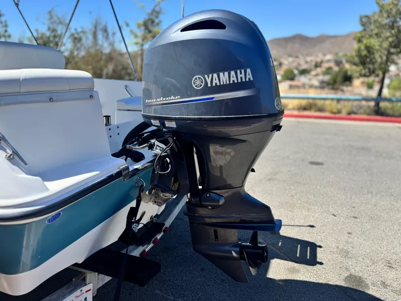 Slide: The Image of 2017 Edgewater 170CC boat with Yamaha four-stroke outboard motor, parked outdoors. - 6