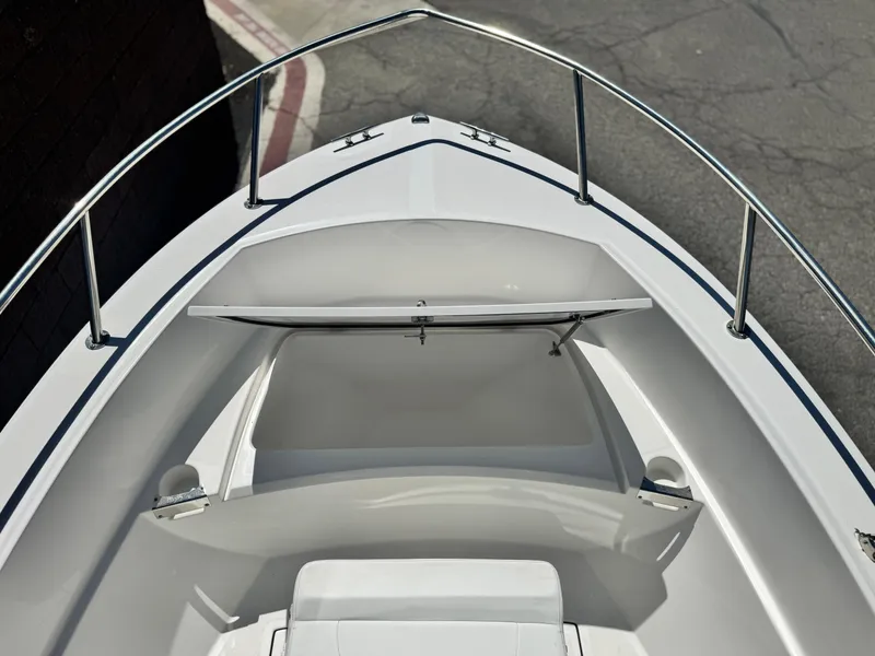 Slide: The Image of 2017 Edgewater 170CC boat bow with open storage compartment and railing. - 9