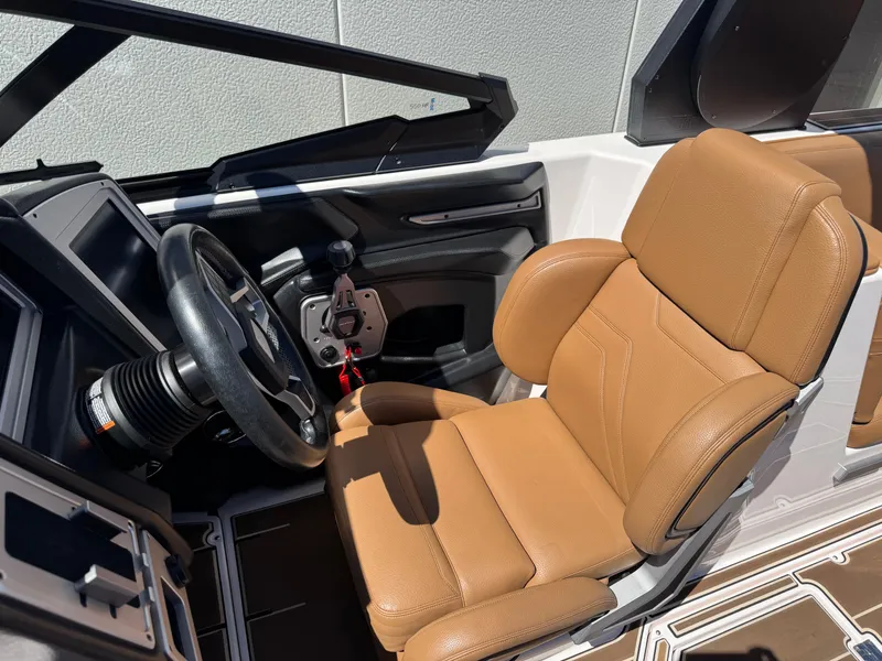 Slide: The Image of 2021 Supra SL 550 boat interior with tan leather seat and steering wheel. - 11