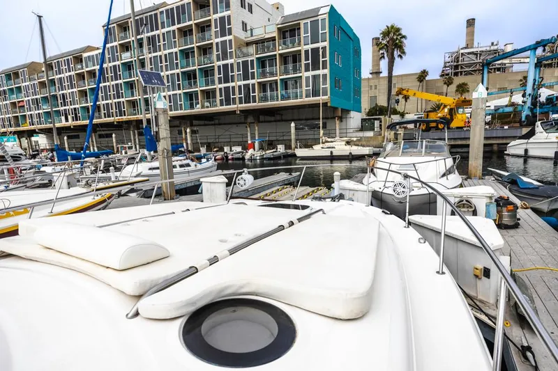 Slide: The Image of 2006 Sea Ray 340 Sundancer docked at a marina with modern buildings in the background. - 17