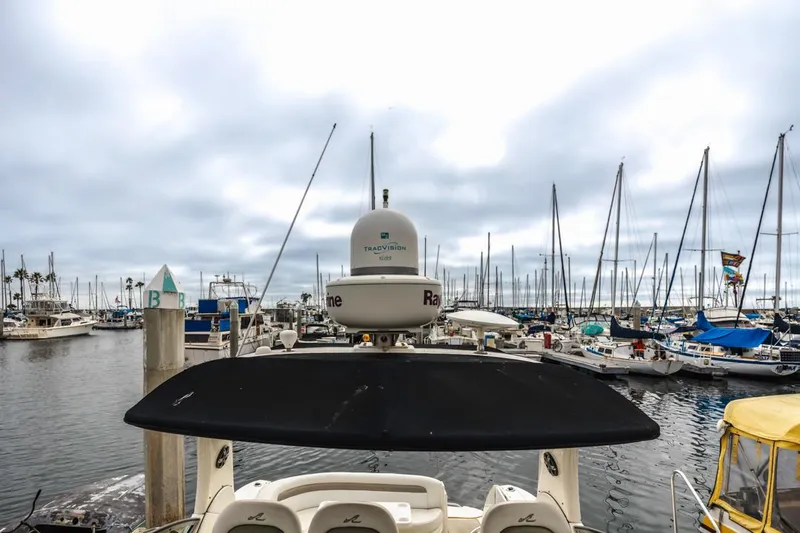 Slide: The Image of 2006 Sea Ray 340 Sundancer docked at a marina with sailboats in the background. - 19
