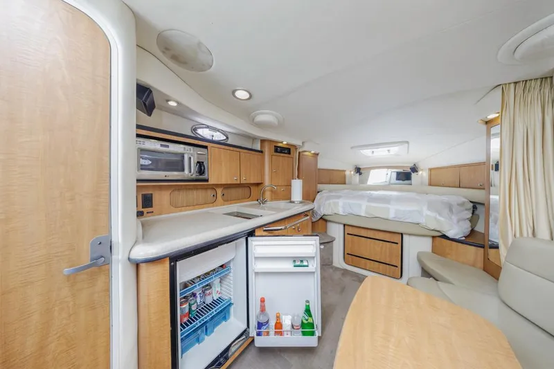 Slide: The Image of 2006 Sea Ray 340 Sundancer interior with kitchenette, bed, and seating area. - 21
