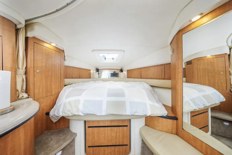 Slide: The Image of 2006 Sea Ray 340 Sundancer cabin interior with bed, wood cabinetry, and mirror. - 22