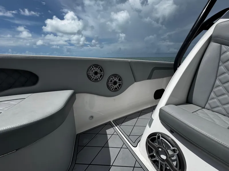 Slide: The Image of Interior of 2023 Avanti 36 boat with gray seating and speakers, under a cloudy sky. - 17