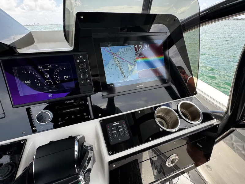 Slide: The Image of 2023 Avanti 36 boat dashboard with navigation screens and controls, overlooking the ocean. - 27