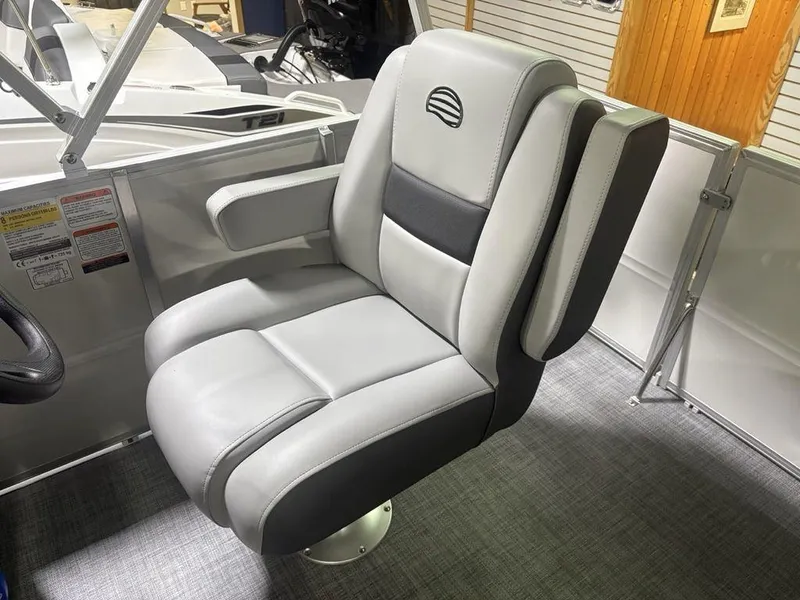 Slide: The Image of Captain's chair in 2026 Sun Tracker PARTY BARGE® 16 DLX, featuring gray upholstery and armrests. - 16