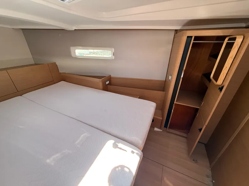 Slide: The Image of Interior cabin of 2021 Jeanneau Sun Odyssey 410 yacht, featuring bed and wooden storage. - 10