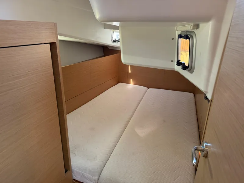 Slide: The Image of Cozy cabin interior of 2021 Jeanneau Sun Odyssey 410 sailboat with wooden finish and window. - 11