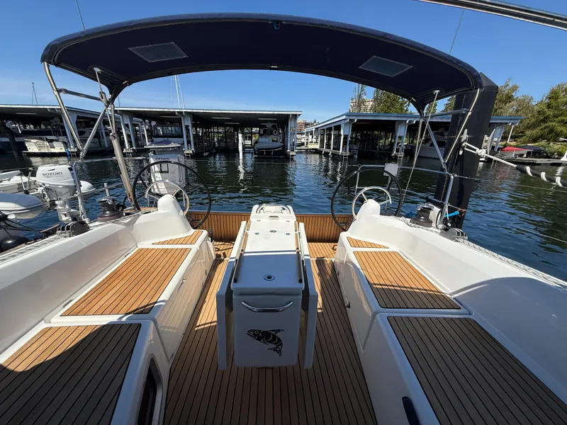 Slide: The Image of 2021 Jeanneau Sun Odyssey 410 sailboat cockpit with teak flooring and dual steering wheels. - 3
