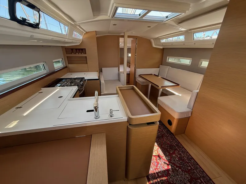 Slide: The Image of Interior of 2021 Jeanneau Sun Odyssey 410 yacht, featuring modern kitchen and dining area. - 5