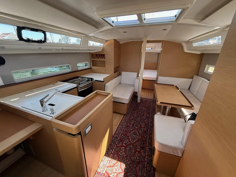 Slide: The Image of Interior of 2021 Jeanneau Sun Odyssey 410 yacht, featuring modern kitchen and seating area. - 6