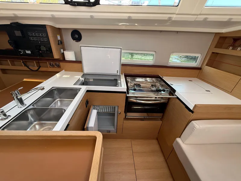 Slide: The Image of Modern kitchen interior of 2021 Jeanneau Sun Odyssey 410 yacht with sleek appliances and wood finish. - 8