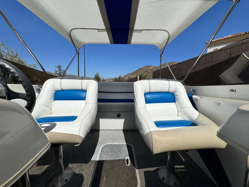 Slide: The Image of Interior of a 1998 Nordic 25 Scandia boat with white and blue seating. - 18