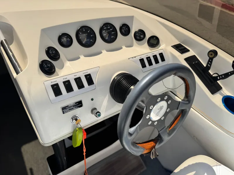 Slide: The Image of Control panel of a 1998 Nordic 25 Scandia boat with steering wheel and gauges. - 25