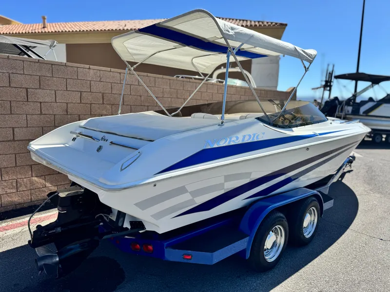 Slide: The Image of 1998 Nordic 25 Scandia boat with canopy on trailer, parked outdoors. - 5