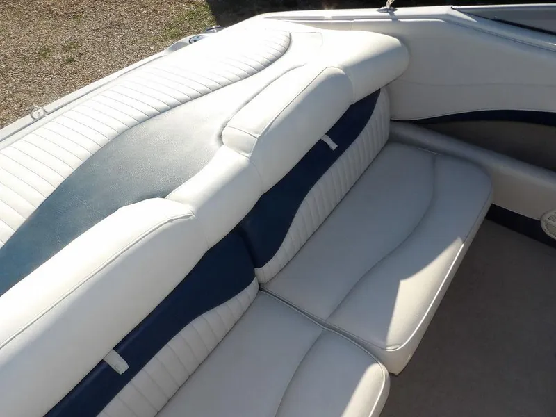 Slide: The Image of 2004 Crownline 202BR boat interior with white and blue cushioned seating. - 12