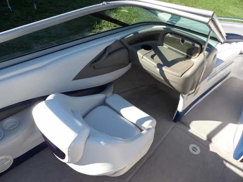 Slide: The Image of Interior of a 2004 Crownline 202BR boat, featuring white seating and a sleek dashboard. - 14