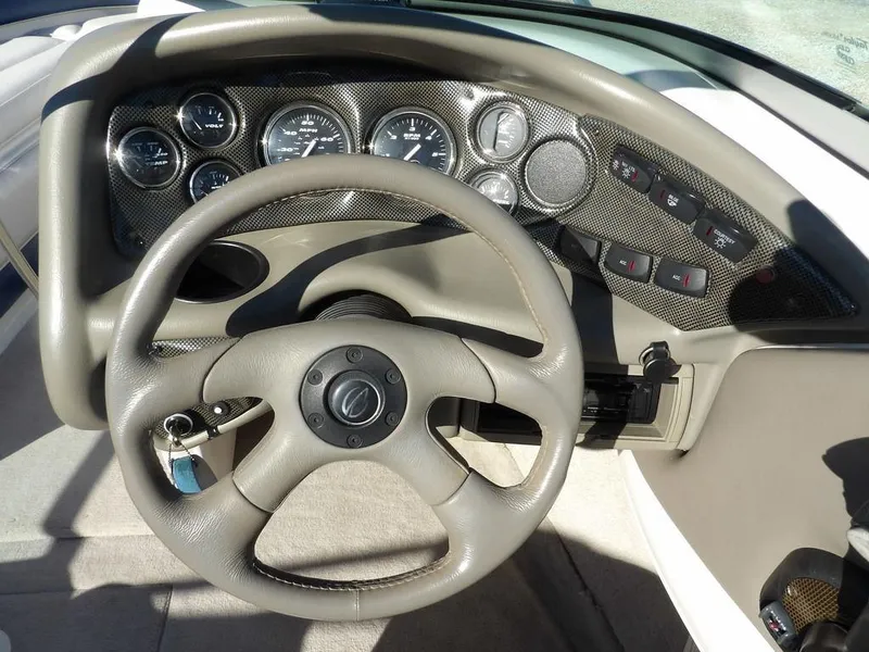 Slide: The Image of Steering wheel and dashboard of a 2004 Crownline 202BR boat, featuring gauges and controls. - 15