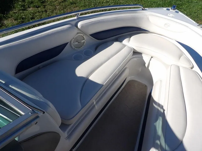 Slide: The Image of 2004 Crownline 202BR boat interior with white cushioned seating and cup holders. - 21