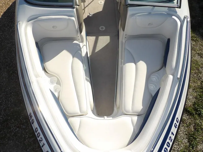Slide: The Image of 2004 Crownline 202BR boat interior with white seating and cup holders. - 22