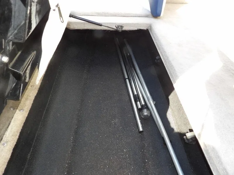 Slide: The Image of Storage compartment in a 2004 Crownline 202BR boat with metal poles inside. - 23