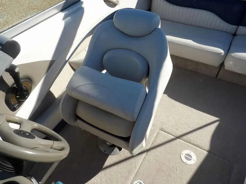 Slide: The Image of 2004 Crownline 202BR boat interior with steering wheel and cushioned seating. - 25