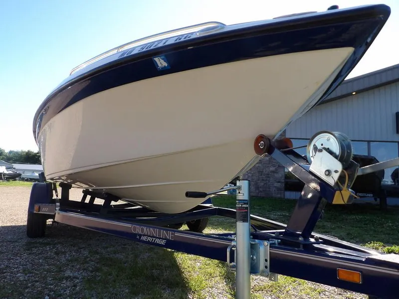 Slide: The Image of 2004 Crownline 202BR boat on trailer, parked outdoors, showcasing sleek hull design. - 32