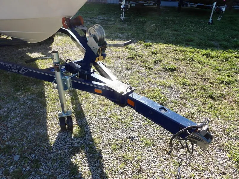 Slide: The Image of Trailer hitch of a 2004 Crownline 202BR boat on gravel and grass. - 35