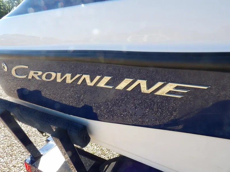 Slide: The Image of 2004 Crownline 202BR boat logo on a blue and white hull. - 36