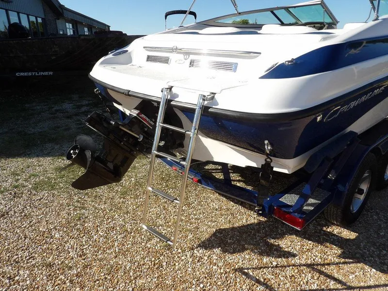 Slide: The Image of 2004 Crownline 202BR boat with ladder and trailer on gravel surface. - 37