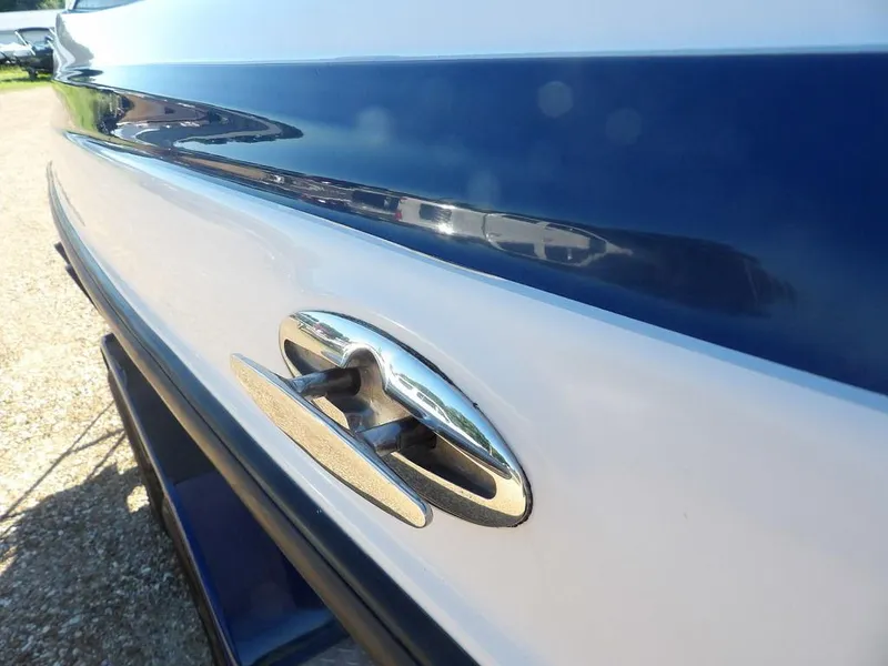 Slide: The Image of Close-up of a 2004 Crownline 202BR boat's sleek blue and white exterior with chrome detail. - 39