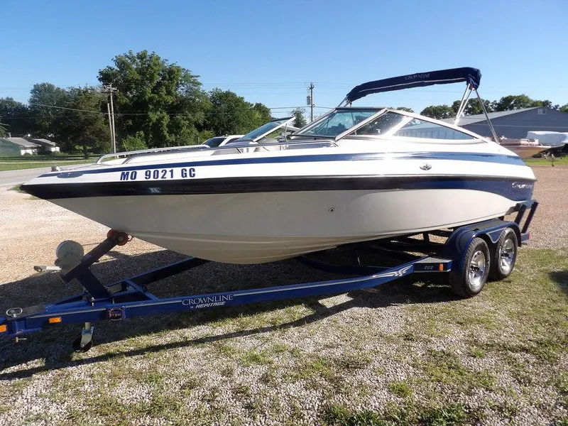 Slide: The Image of 2004 Crownline 202BR boat on trailer, parked outdoors on gravel. - 4