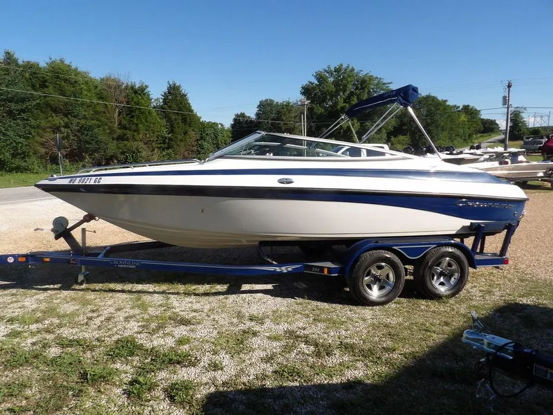 Slide: The Image of 2004 Crownline 202BR boat on trailer, parked outdoors on gravel. - 6