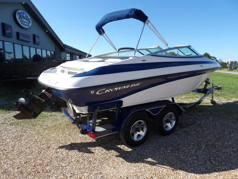 Slide: The Image of 2004 Crownline 202BR boat on trailer, parked outside marine dealership. - 7