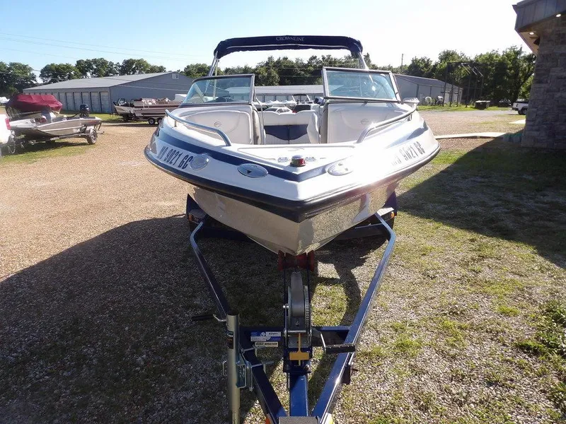 Slide: The Image of 2004 Crownline 202BR boat on trailer, parked outdoors in a sunny setting. - 8