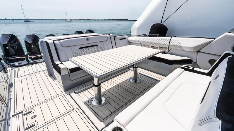 Slide: The Image of 2025 Cigarette 52 Thunder boat interior with seating and table, overlooking calm waters. - 11