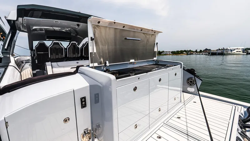 Slide: The Image of 2025 Cigarette 52 Thunder yacht with open deck storage, docked by the water. - 17
