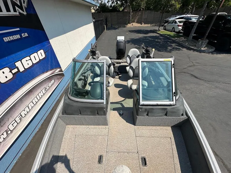 Slide: The Image of 2015 Alumacraft Competitor 165 Sport boat, parked outdoors, featuring dual windshields and seating. - 25