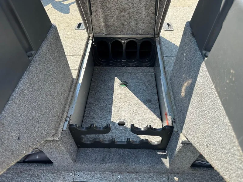 Slide: The Image of 2015 Alumacraft Competitor 165 Sport boat storage compartment with rod holders. - 27