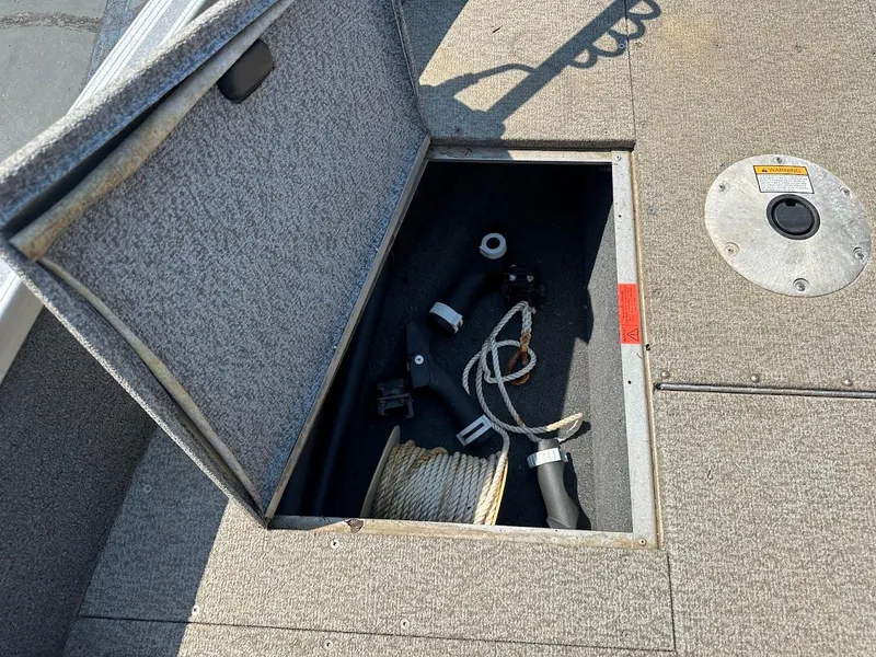 Slide: The Image of Open storage compartment in 2015 Alumacraft Competitor 165 Sport boat, containing ropes and accessories. - 29