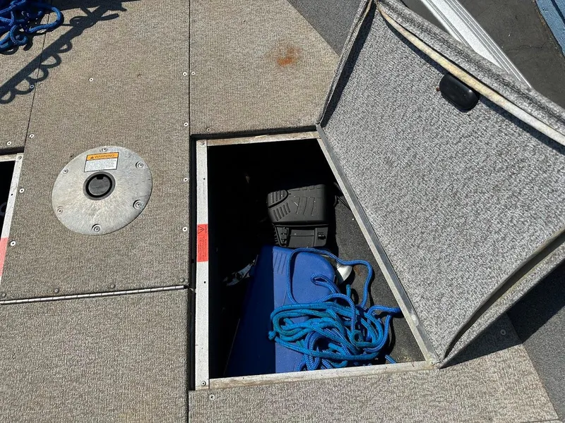 Slide: The Image of 2015 Alumacraft Competitor 165 Sport boat storage compartment with blue rope and equipment. - 30