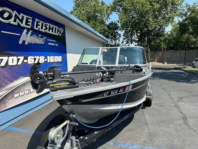 Slide: The Image of 2015 Alumacraft Competitor 165 Sport boat parked outside a marine shop. - 5